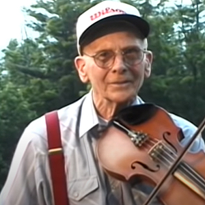 NC Fiddler Red Wilson wearing a Wilson sporting goods hat and with his fiddle