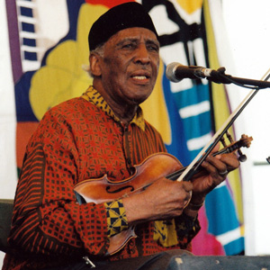 Old-time-fiddler-Louie-Bluie-at-Jazz-Fest African American old time fiddle Louie Bluie seated with his fiddle at New Orleans Jazz Fest